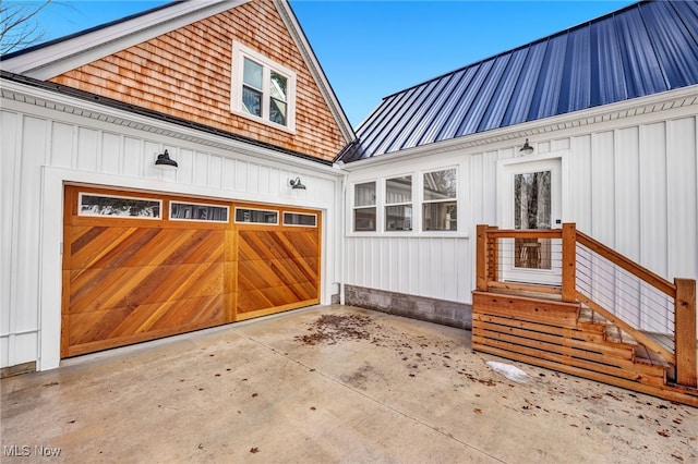 exterior space with board and batten siding, metal roof, driveway, and an attached garage