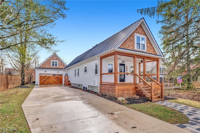 view of front of house featuring metal roof, covered porch, an outdoor structure, fence, and a standing seam roof