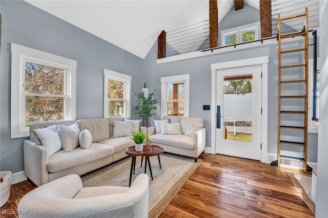 living room with high vaulted ceiling, wood-type flooring, beam ceiling, and baseboards