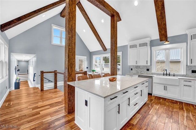 kitchen featuring visible vents, dishwasher, a healthy amount of sunlight, light wood-style floors, and a sink