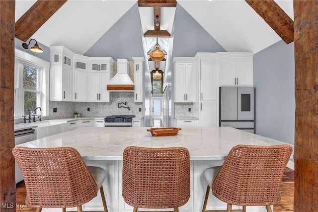 kitchen featuring custom exhaust hood, range, backsplash, dishwasher, and refrigerator with glass door