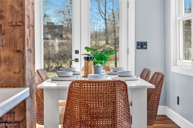 dining area with baseboards and wood finished floors