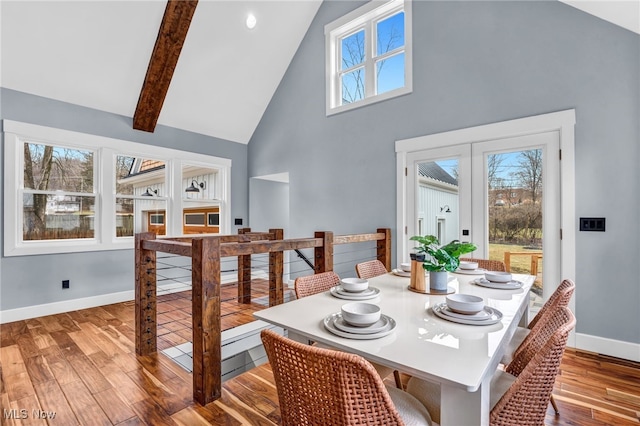 dining space featuring baseboards, wood finished floors, beamed ceiling, french doors, and high vaulted ceiling