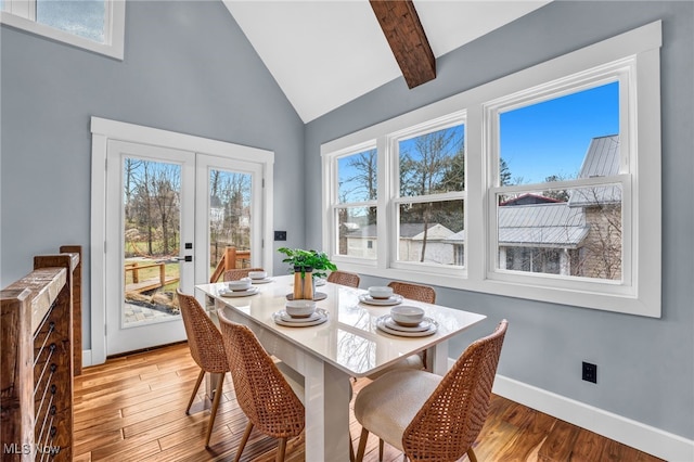 dining room with vaulted ceiling with beams, french doors, light wood-type flooring, and baseboards