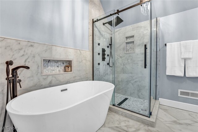 bathroom with a freestanding tub, visible vents, tile walls, marble finish floor, and a shower stall