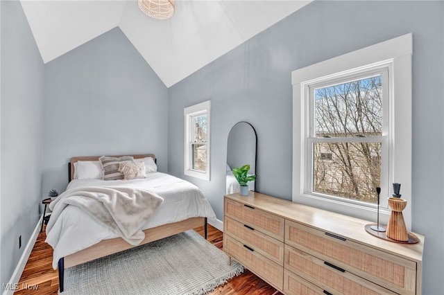 bedroom with baseboards, vaulted ceiling, and wood finished floors