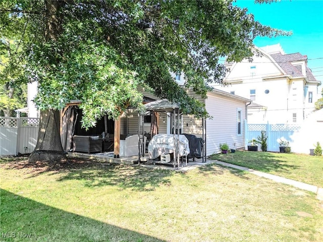 back of property with a patio area, a lawn, and fence