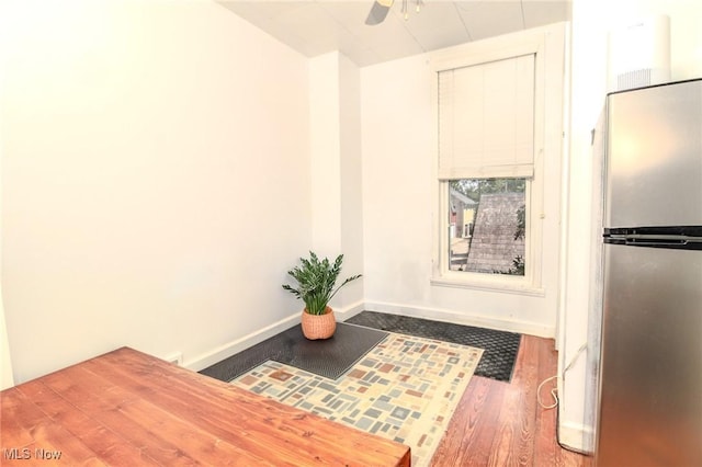 kitchen featuring stainless steel fridge, ceiling fan, baseboards, and wood finished floors