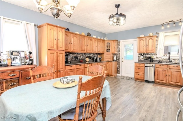 kitchen featuring light wood-style floors, a chandelier, a sink, and tasteful backsplash