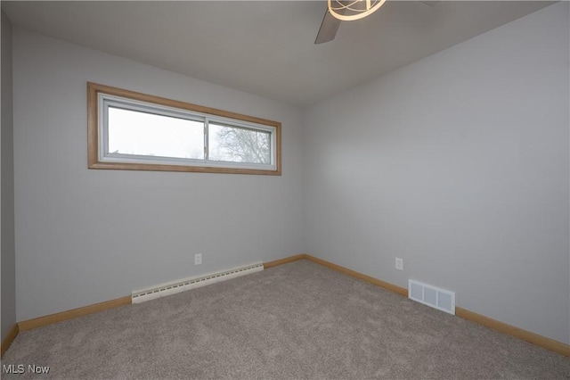 carpeted spare room featuring baseboards, visible vents, and baseboard heating