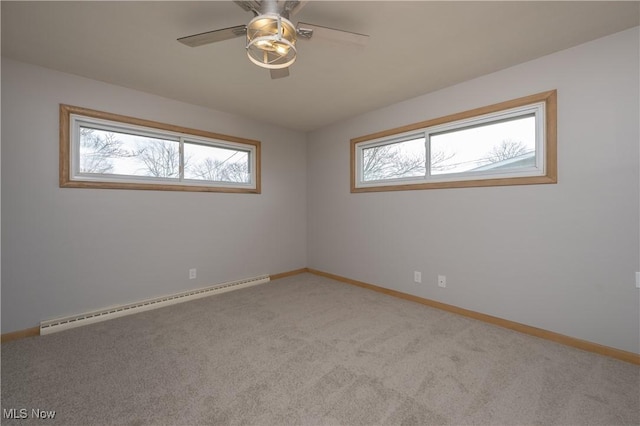 unfurnished room featuring a baseboard heating unit, a healthy amount of sunlight, carpet flooring, and baseboards