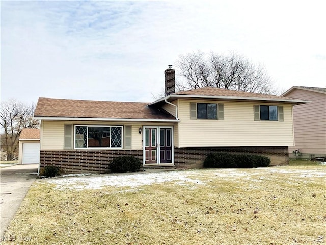 tri-level home featuring a front yard, brick siding, and a chimney