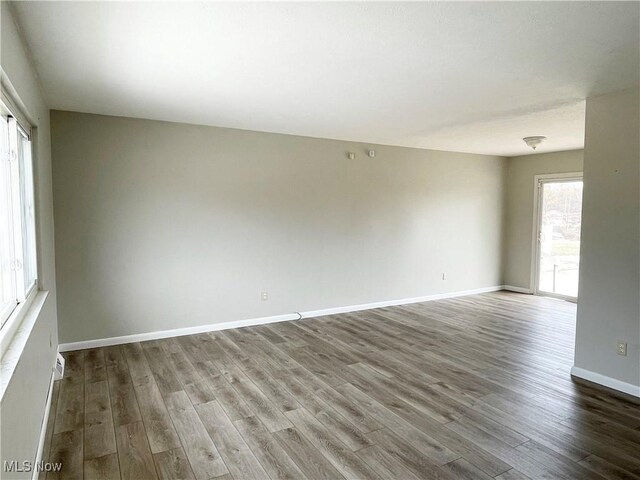 empty room featuring baseboards and wood finished floors