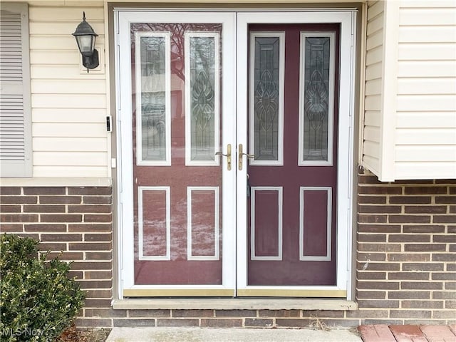 property entrance with brick siding and french doors