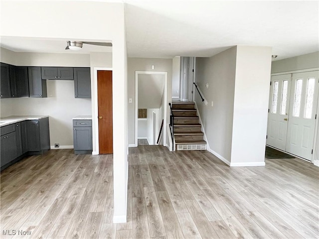 kitchen featuring light wood finished floors, baseboards, and gray cabinetry