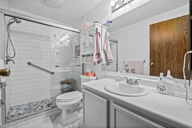 bathroom with a stall shower, vanity, and toilet