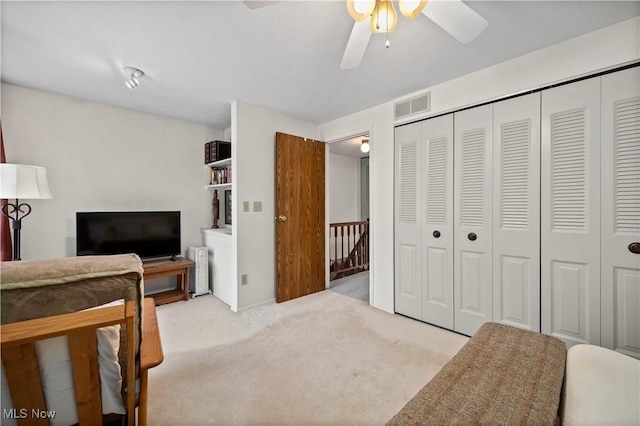 carpeted bedroom featuring ceiling fan, a closet, and visible vents