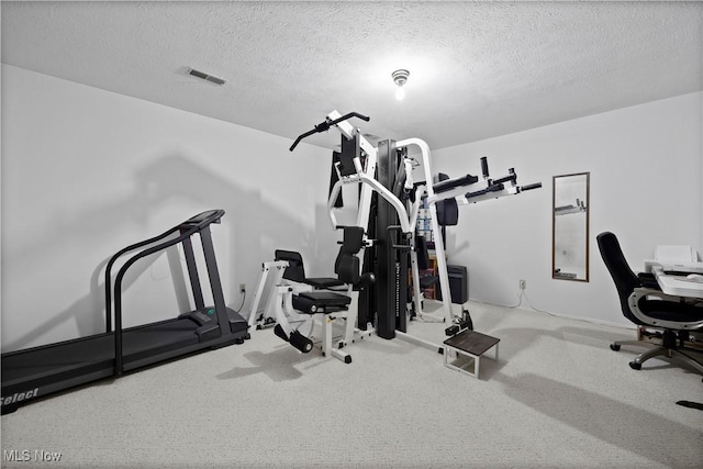 workout room featuring a textured ceiling, carpet flooring, and visible vents