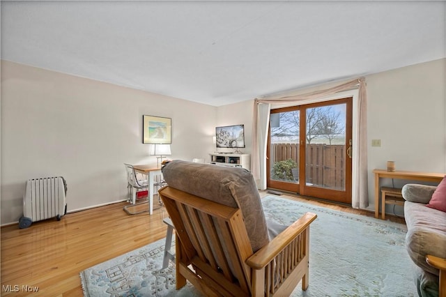 sitting room with radiator heating unit and wood finished floors