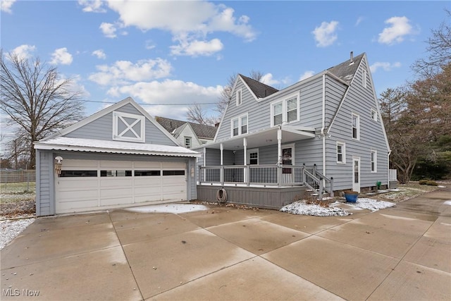 view of front of house with a porch, a detached garage, and an outdoor structure