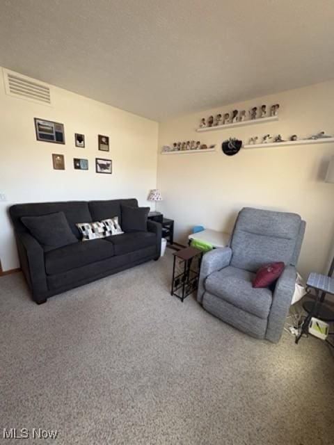 carpeted living area with visible vents and a textured ceiling