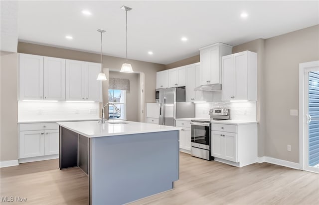 kitchen with under cabinet range hood, stainless steel appliances, a sink, light wood-style floors, and light countertops