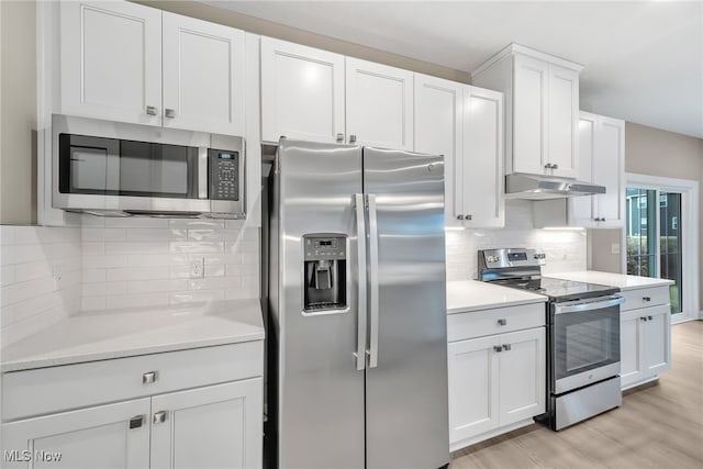 kitchen featuring white cabinets, decorative backsplash, stainless steel appliances, light countertops, and under cabinet range hood