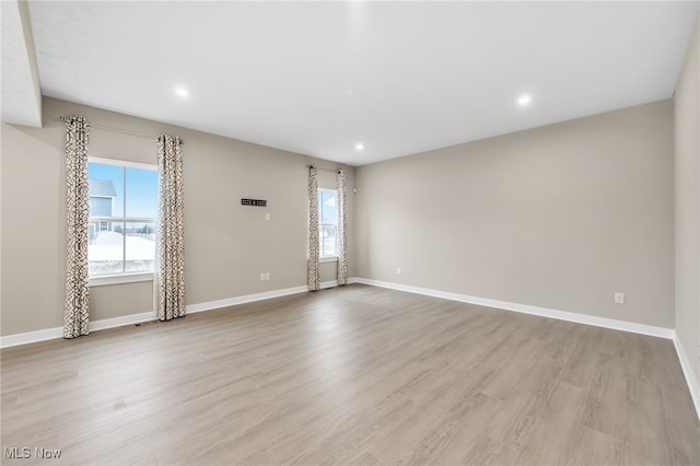 spare room with recessed lighting, light wood-style flooring, and baseboards