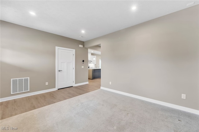 spare room with light carpet, baseboards, visible vents, and recessed lighting