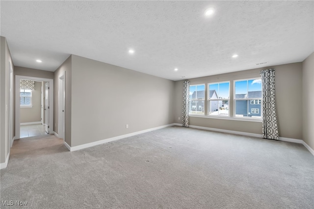 unfurnished room with a textured ceiling, baseboards, carpet flooring, and recessed lighting