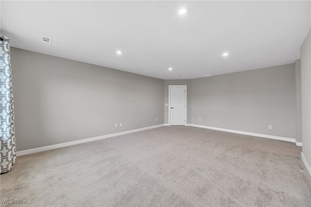 carpeted spare room featuring visible vents, baseboards, and recessed lighting