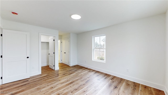 unfurnished bedroom featuring light wood-type flooring and baseboards