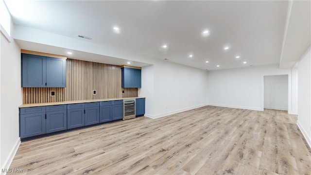 kitchen featuring beverage cooler, blue cabinets, light wood finished floors, and recessed lighting