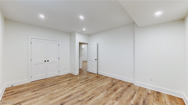 spare room with baseboards, light wood-type flooring, and recessed lighting