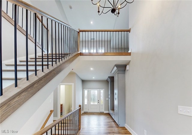 entryway with baseboards, a towering ceiling, wood finished floors, a chandelier, and recessed lighting