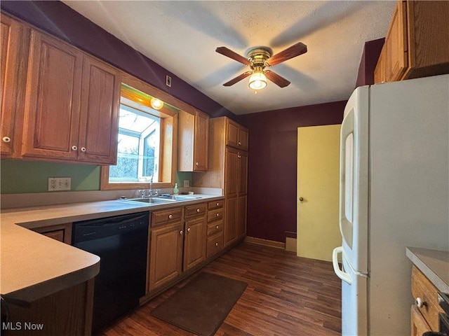 kitchen with dark wood-style floors, black dishwasher, a sink, and freestanding refrigerator