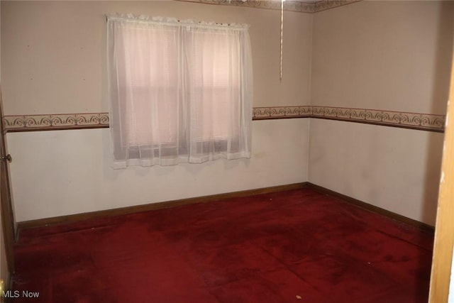 empty room featuring baseboards and a wealth of natural light