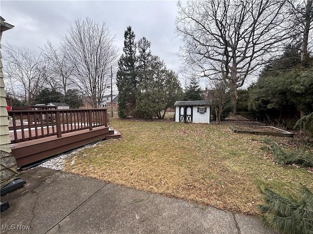 view of yard featuring a storage shed, a deck, and an outdoor structure