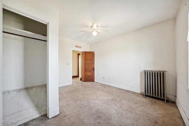 unfurnished bedroom with carpet floors, a closet, baseboards, and radiator heating unit