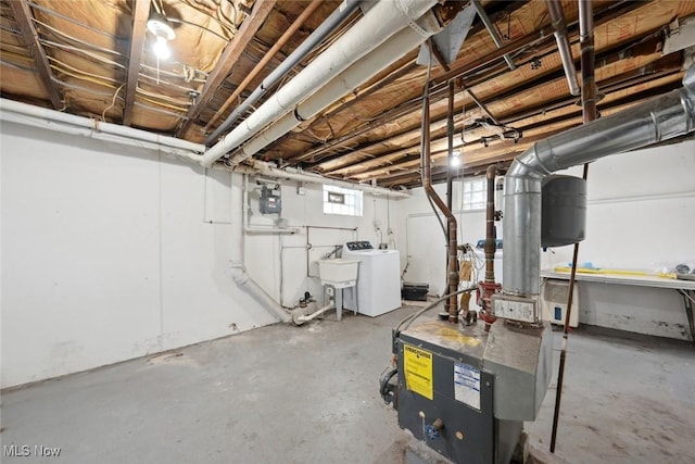 basement featuring washer / clothes dryer, a heating unit, and a sink