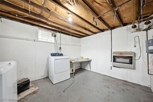 below grade area featuring heating unit, fridge, and independent washer and dryer