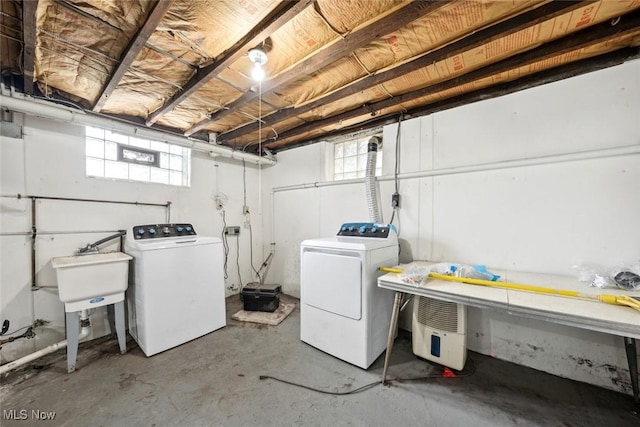 clothes washing area with laundry area, a sink, and washing machine and clothes dryer