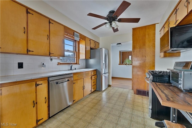 kitchen with stainless steel appliances, visible vents, light countertops, backsplash, and light floors