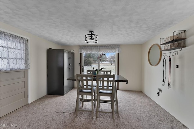 dining area featuring light carpet and a textured ceiling