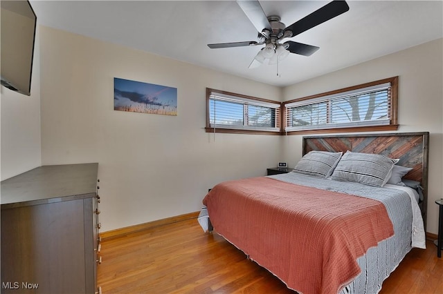 bedroom featuring ceiling fan, wood finished floors, and baseboards