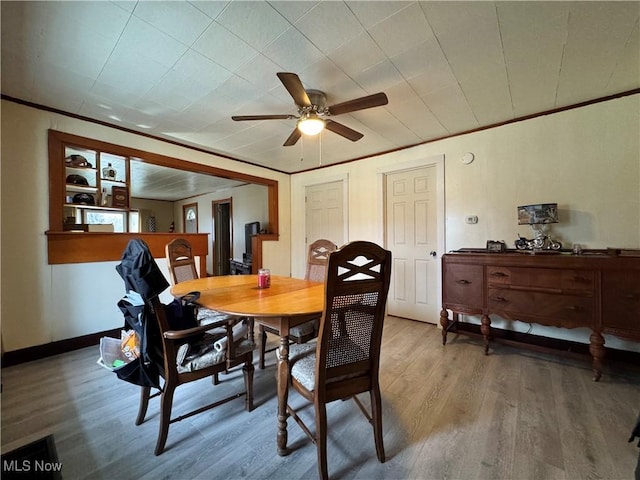 dining area with baseboards, wood finished floors, a ceiling fan, and crown molding