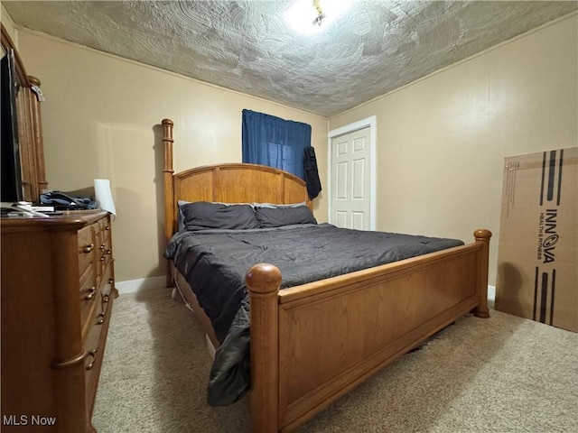 bedroom featuring a textured ceiling, carpet floors, and baseboards