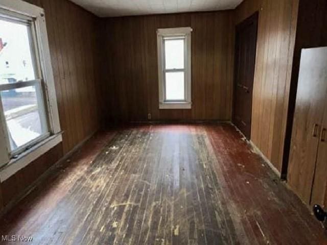 unfurnished room featuring wood walls and hardwood / wood-style floors