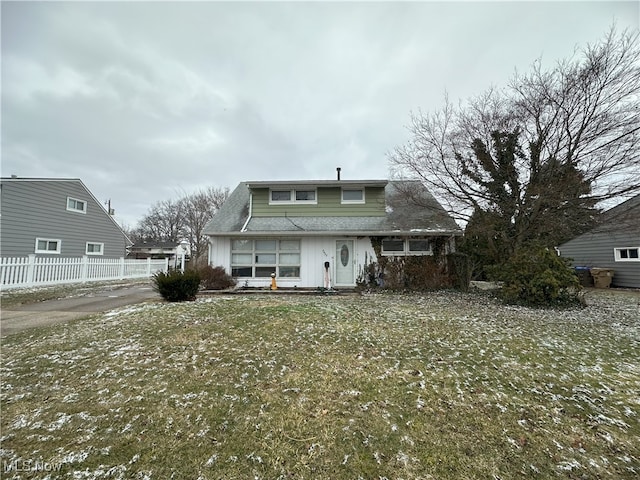 rear view of house with roof with shingles and fence