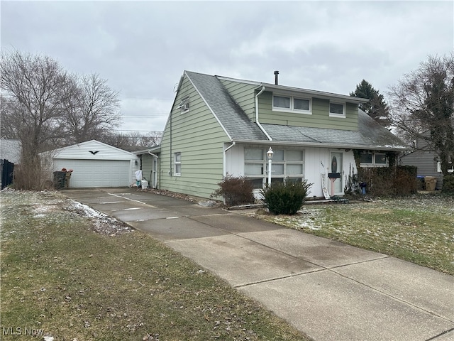 view of front of home featuring a shingled roof, an outdoor structure, and a detached garage